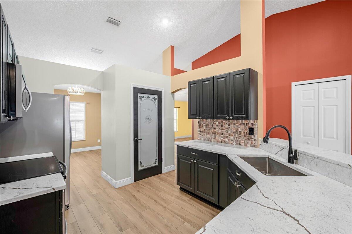 6445 Ainsworth Road Cocoa, FL 32927 - Photo 15 of 31 a kitchen with a sink and a stove top oven