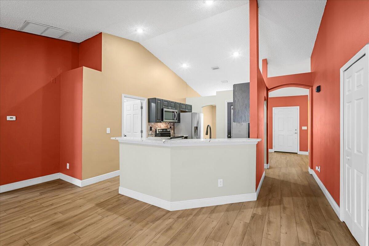 6445 Ainsworth Road Cocoa, FL 32927 - Photo 16 of 31 a living room with stainless steel appliances kitchen island granite countertop wooden floor