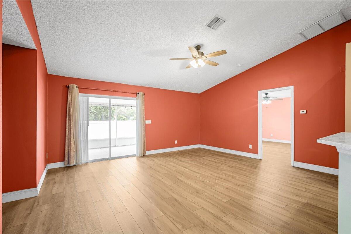 6445 Ainsworth Road Cocoa, FL 32927 - Photo 18 of 31 a view of an empty room with a window and wooden floor