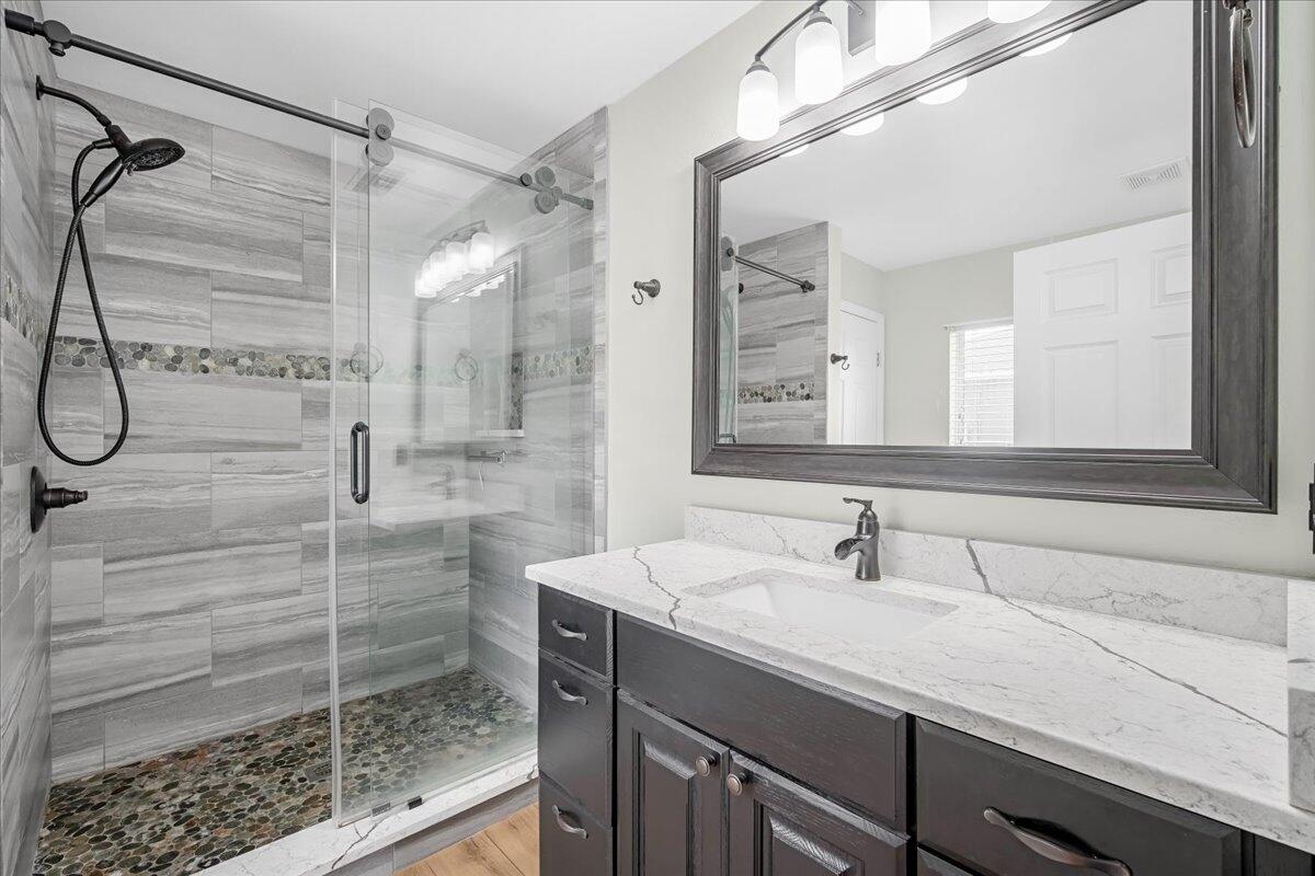 6445 Ainsworth Road Cocoa, FL 32927 - Photo 22 of 31 a bathroom with a shower sink and mirror