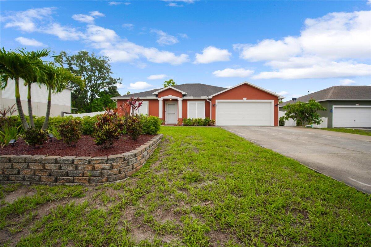6445 Ainsworth Road Cocoa, FL 32927 - Photo 3 of 31 a view of a house with a big yard plants and palm trees