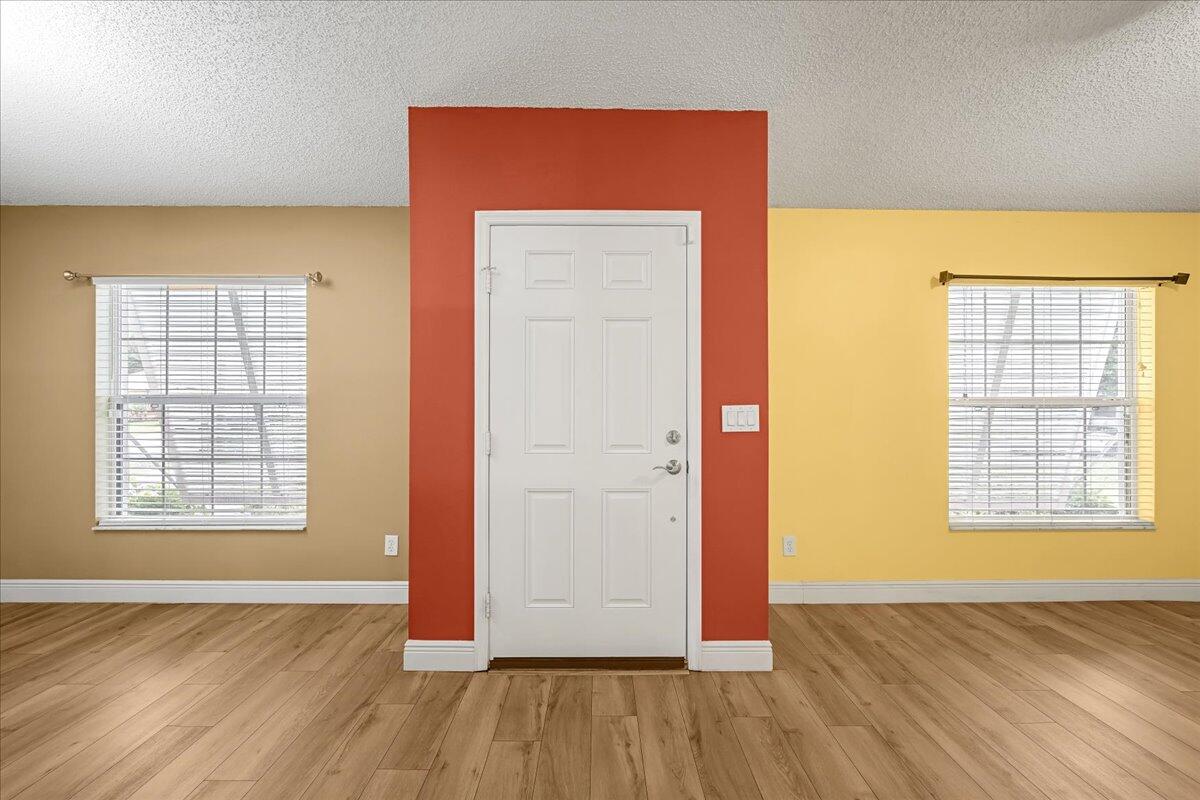 6445 Ainsworth Road Cocoa, FL 32927 - Photo 7 of 31 an empty room with wooden floor and windows