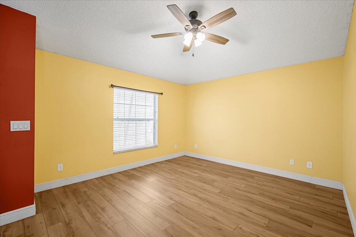 6445 Ainsworth Road Cocoa, FL 32927 - Photo 8 of 31 a view of an empty room with wooden floor and a window
