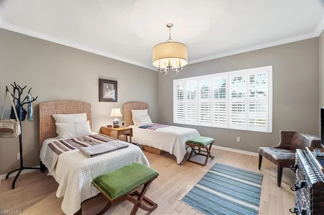 a bedroom with two beds and a chandelier