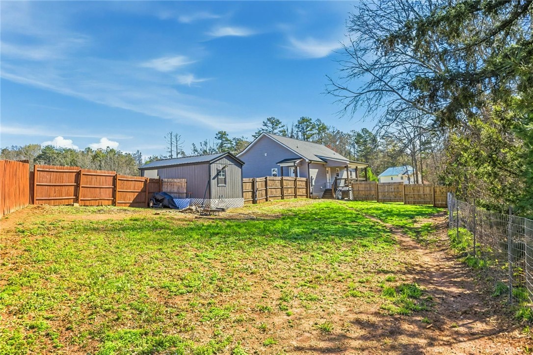745 Dave Nix Road Seneca, SC 29678 - Photo 22 of 23 A spacious backyard with privacy fencing, an additional shed, and a well-maintained lawn.