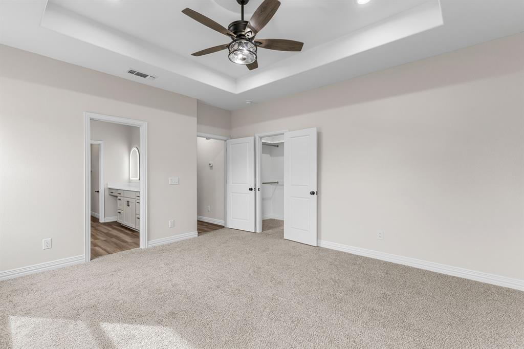 4695 Sisk Road Wichita Falls, TX 76310 - Photo 17 of 32 Unfurnished bedroom featuring a raised ceiling, dark colored carpet, a spacious closet, and ensuite bath