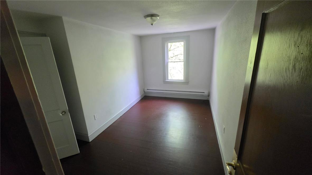 233 East Ridge Street Lansford, PA 18232 - Photo 4 of 10 Hardwood flooring extends throughout this quiet bedroom, offering a simple yet functional living space.