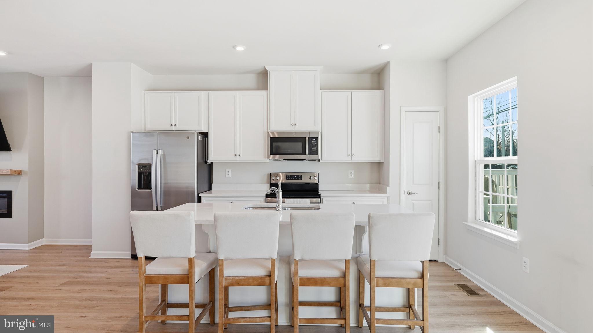 1790 Scenic Loop Culpeper, VA 22701 - Photo 9 of 33 a kitchen with stainless steel appliances a table chairs refrigerator and microwave
