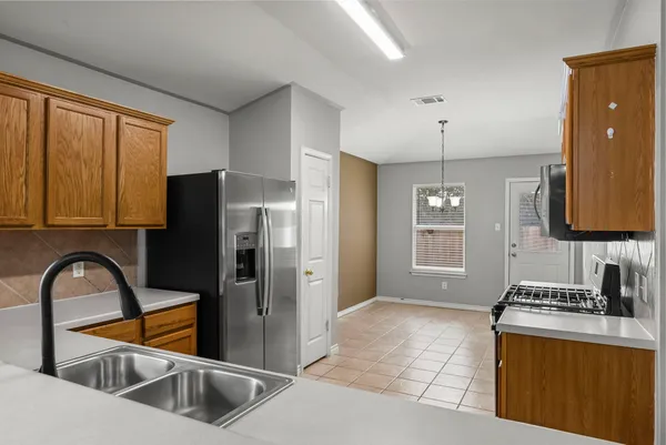 a kitchen with stainless steel appliances granite countertop a refrigerator and a sink