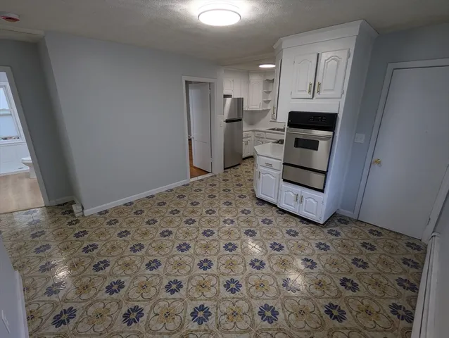 a kitchen with white cabinets and stainless steel appliances