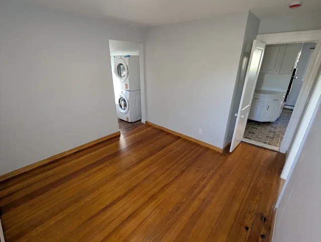 an empty room with wooden floor and mirror