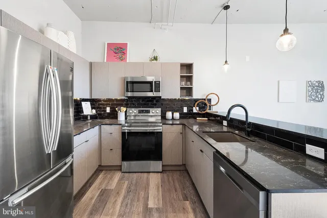a kitchen with stainless steel appliances granite countertop a sink stove and refrigerator