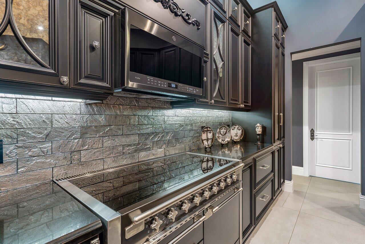 4848 Chamal Circle Boca Raton, FL 33487 - Photo 63 of 88 a kitchen with granite countertop a stove and a microwave