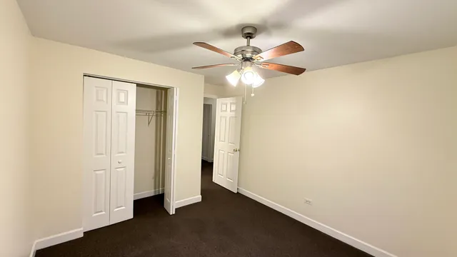 an empty room with a ceiling fan and a window