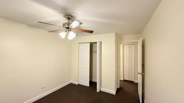 an empty room with a window and a ceiling fan
