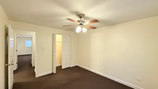 an empty room with a ceiling fan and a window
