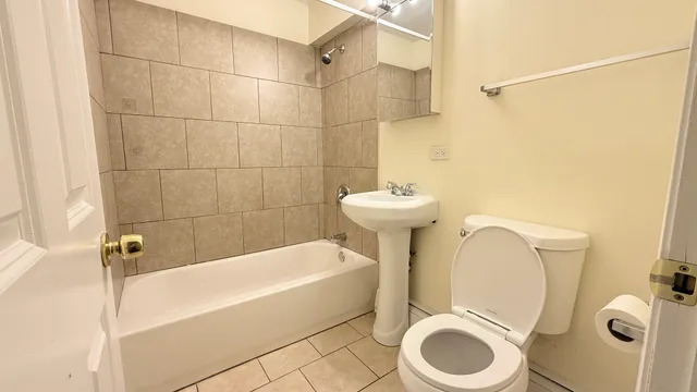 a white toilet sitting next to a bath tub