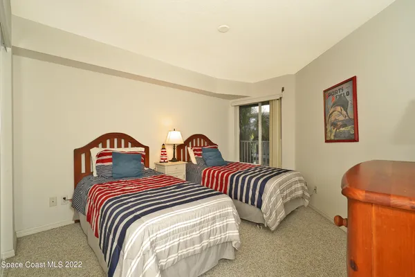 a bedroom with two beds and a painting on the wall