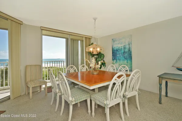 a dining room with furniture a chandelier and wooden floor