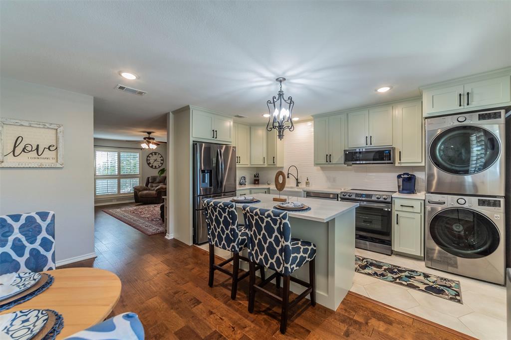 960 Roaring Springs Road, Unit 960 Fort Worth, TX 76114 - Photo 1 of 1 a kitchen with stainless steel appliances granite countertop a stove top oven a sink dishwasher a dining table and chairs with wooden floor