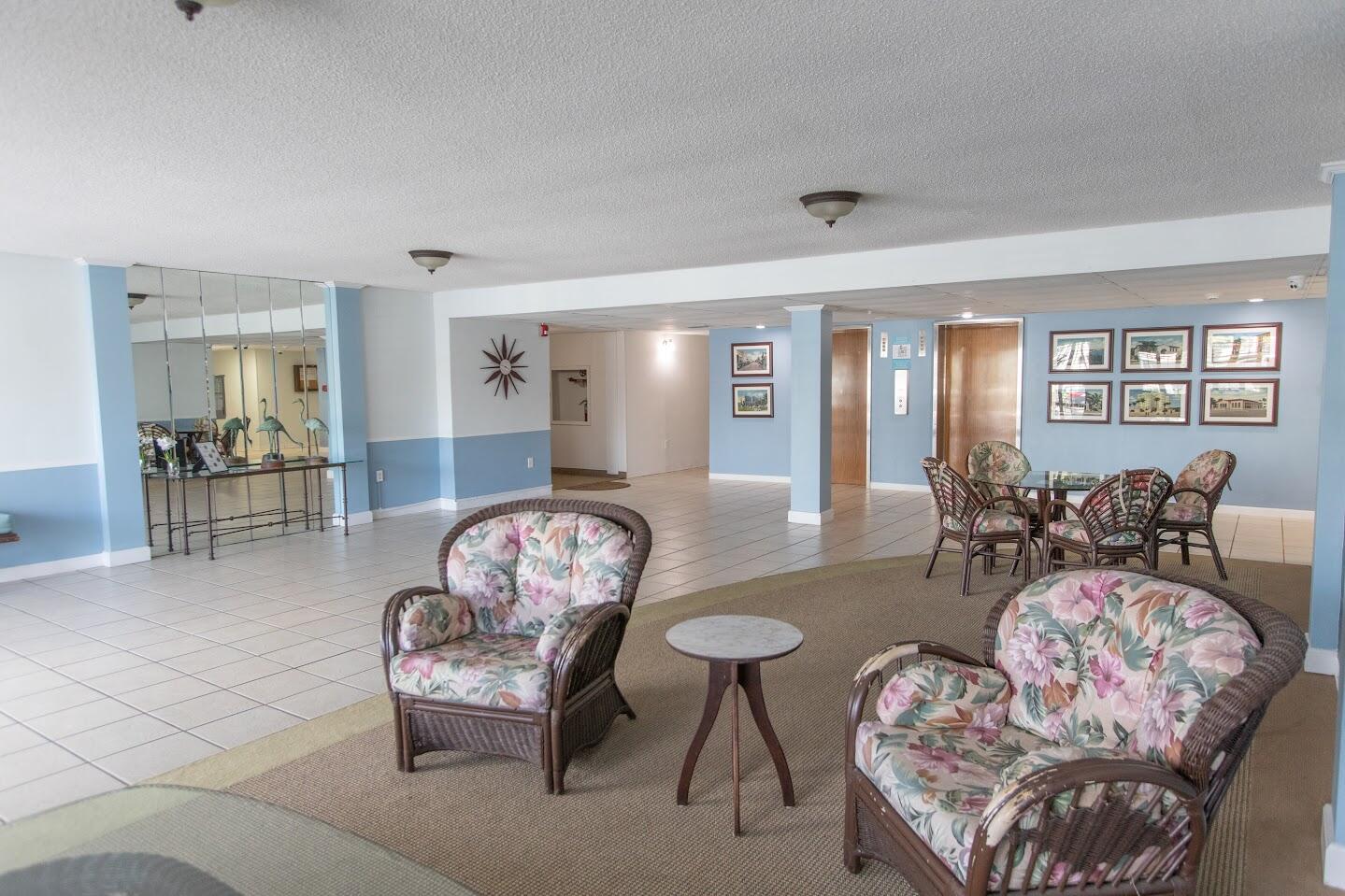a living room with furniture couches and a dining table with wooden floor
