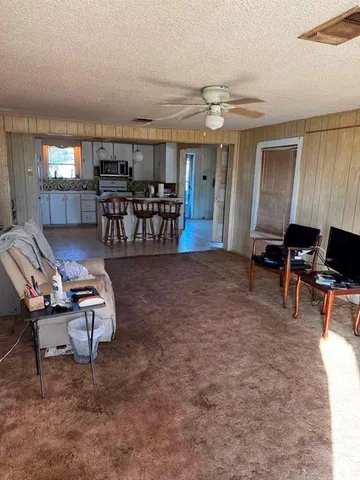 a living room with furniture and kitchen view