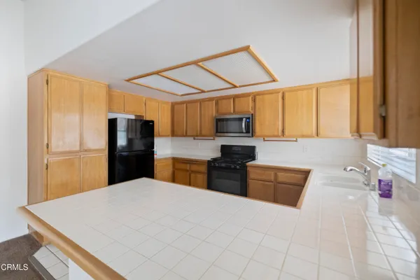 a kitchen with stainless steel appliances kitchen island granite countertop a refrigerator and microwave