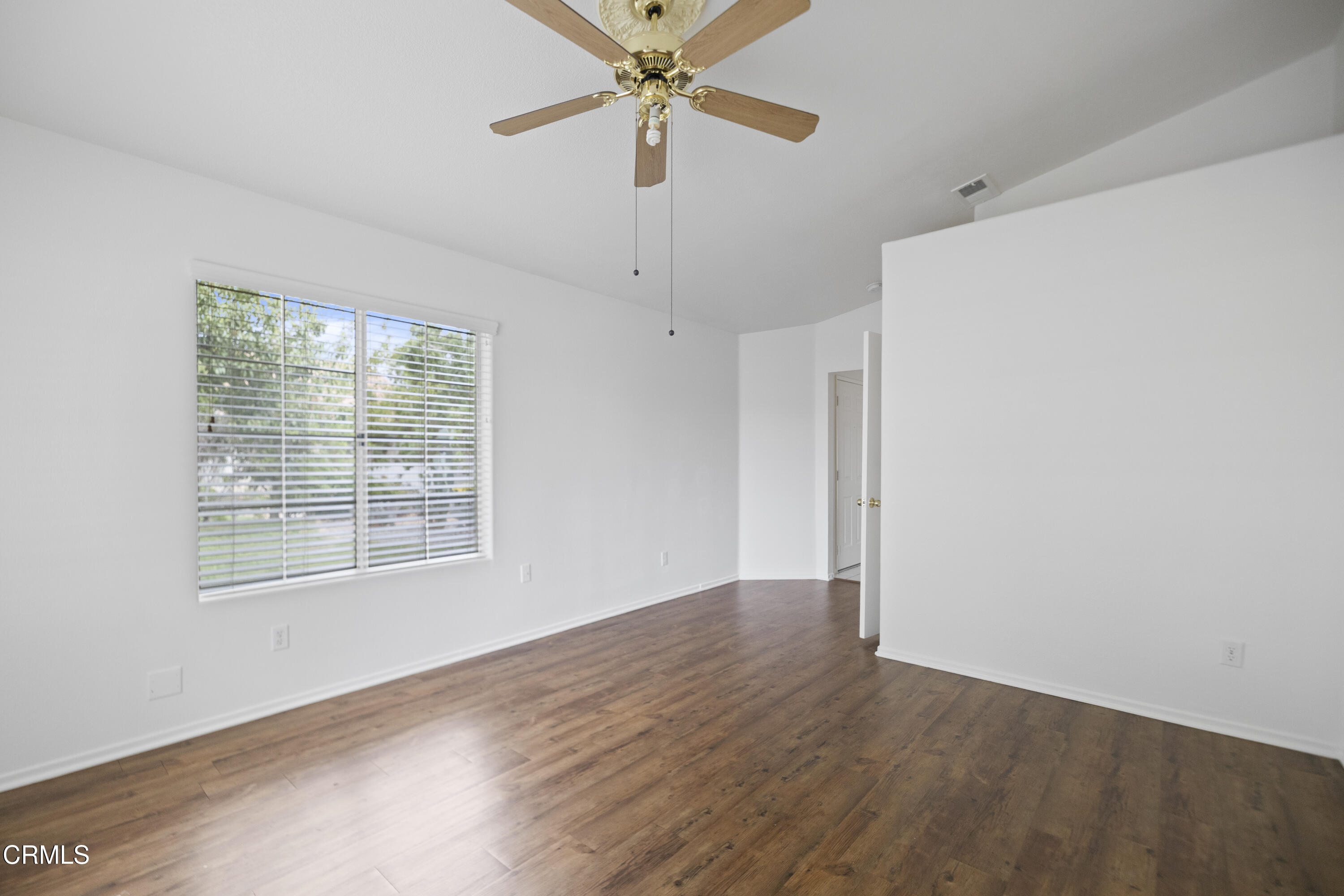 15589 Cheyenne Street Hesperia, CA 92345 - Photo 5 of 12 a view of an empty room with a window and wooden floor