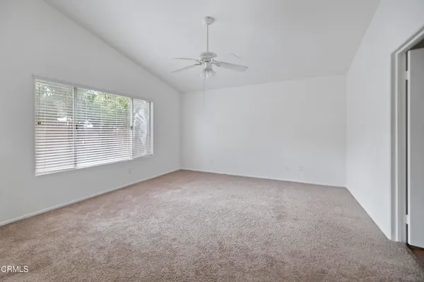 en empty room with windows and ceiling fan