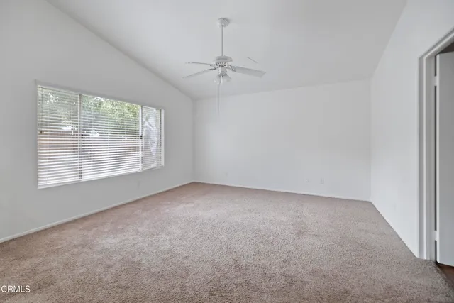 en empty room with windows and ceiling fan
