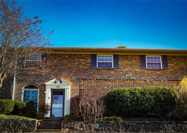 a front view of a house with plants