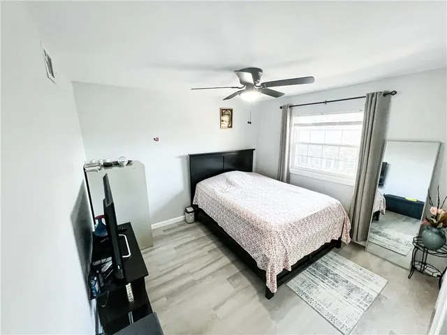 a view of a bedroom with wooden floor and a window