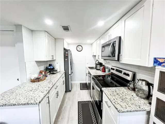 a kitchen with a stove a sink and a microwave