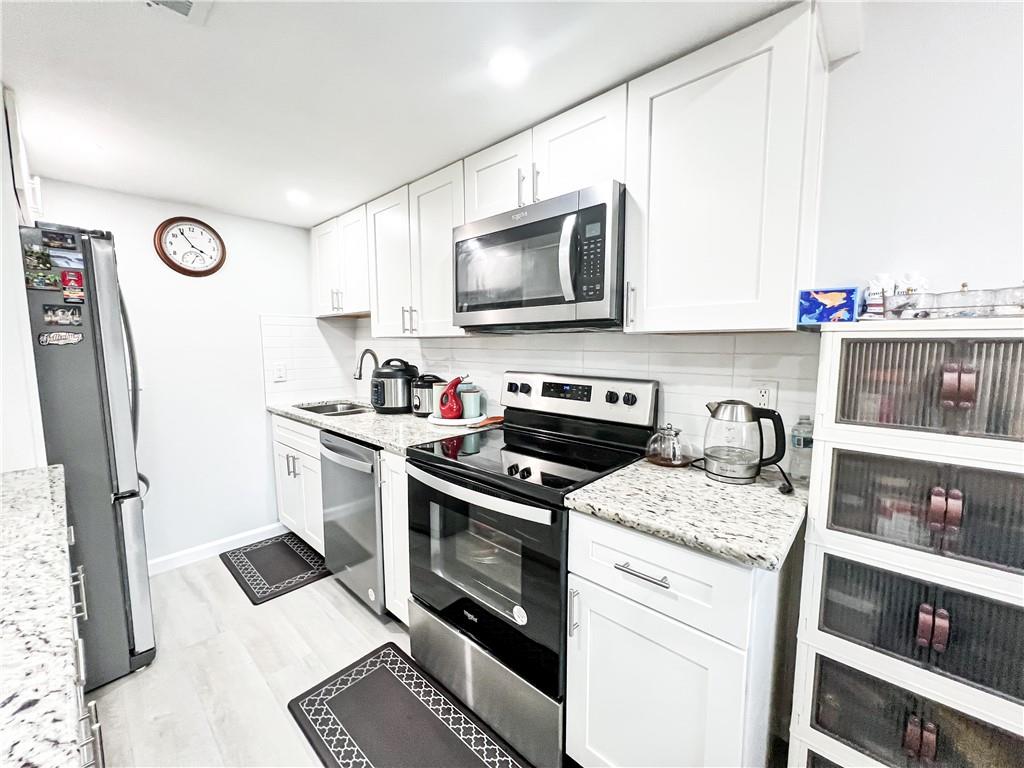 3549 Old Chamblee Tucker Road, Unit J Atlanta, GA 30340 - Photo 35 of 61 a kitchen with a stove a sink and a microwave