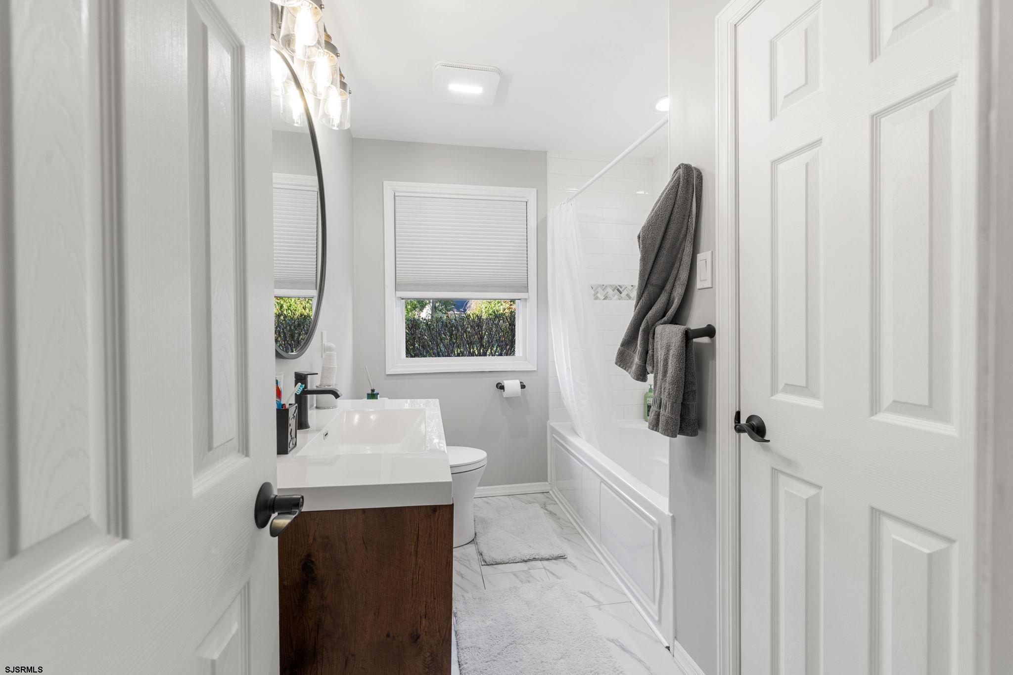 210 Mill Road Absecon, NJ 08201 - Photo 28 of 52 a bathroom with a sink a mirror and a bathtub