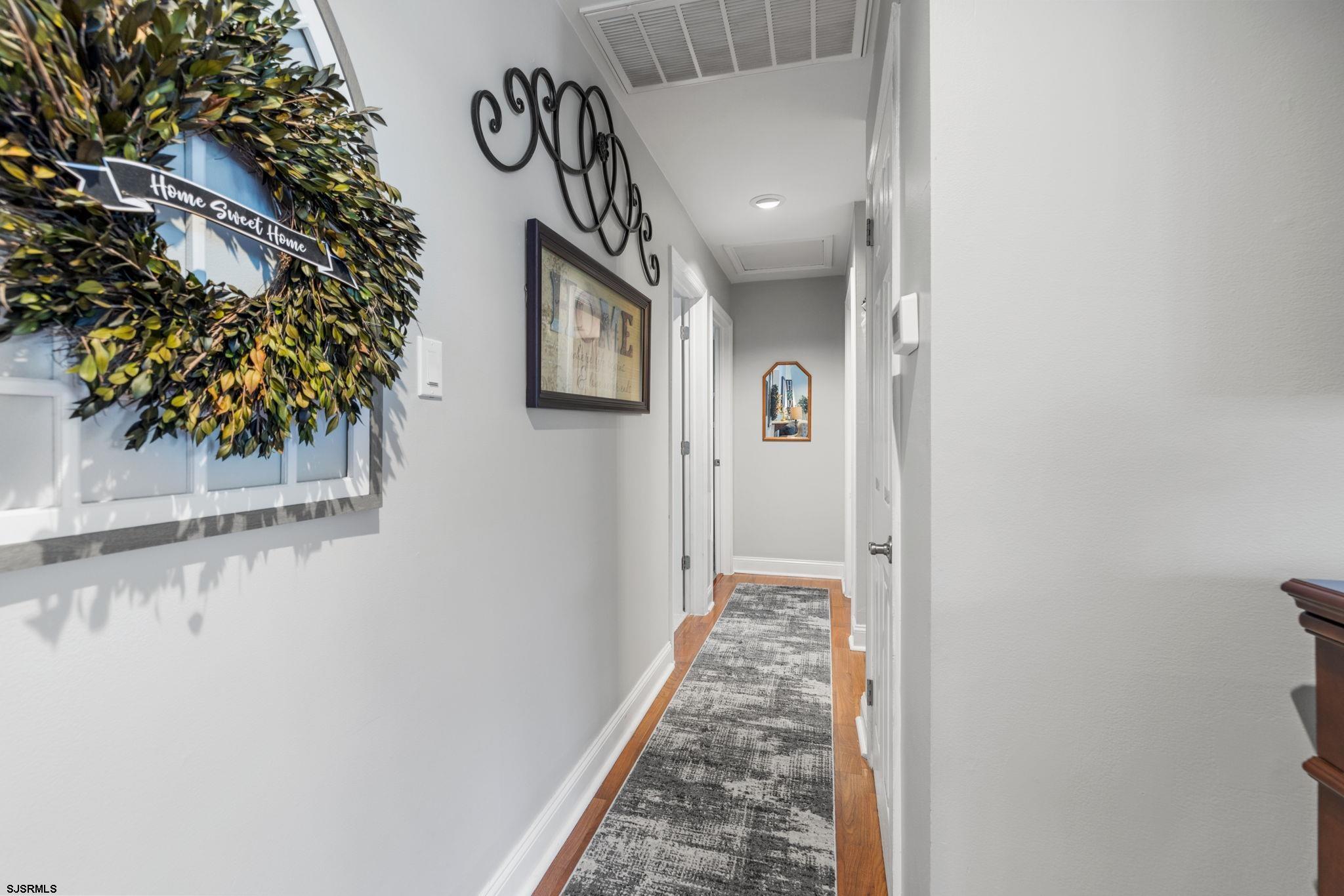 210 Mill Road Absecon, NJ 08201 - Photo 31 of 52 a view of a hallway with wooden floor and a potted plant