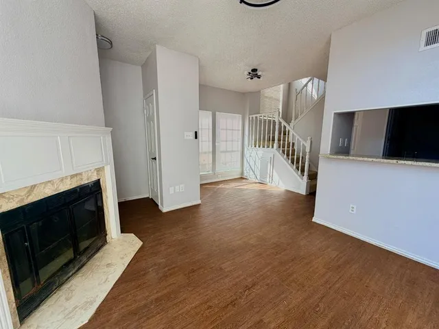 a view of a livingroom with wooden floor and a fireplace