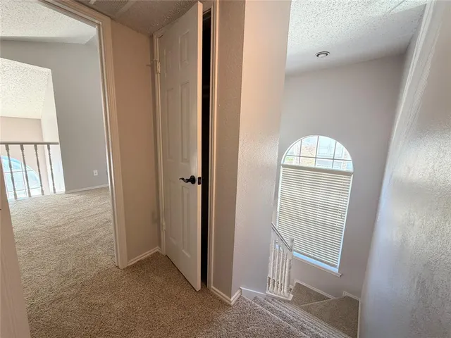 an empty room with wooden floor mirror and windows