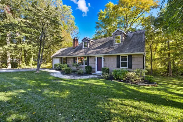 a front view of a house with yard and green space