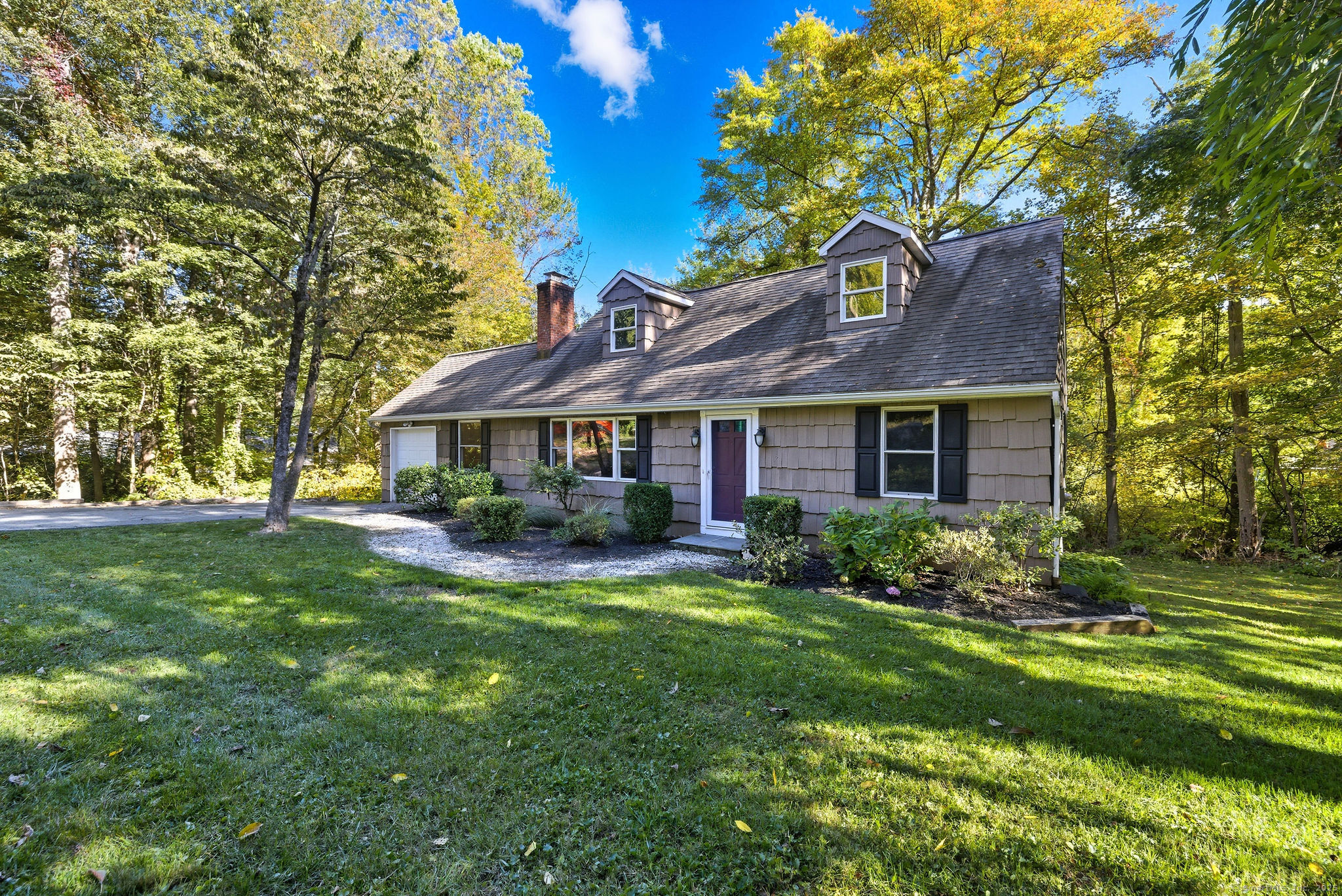 a front view of a house with yard and green space
