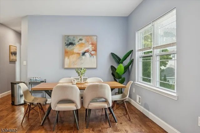 a view of a dining room with furniture a potted plant and wooden floor