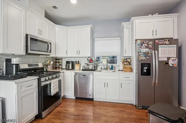 a kitchen with stainless steel appliances granite countertop a refrigerator stove and sink