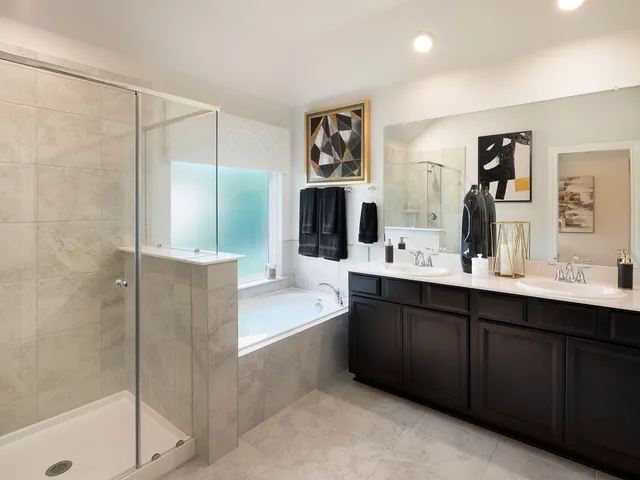 a spacious bathroom with a double vanity sink a mirror and a shower