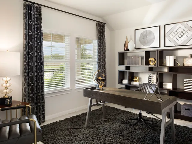 a view of a workspace with furniture and a window