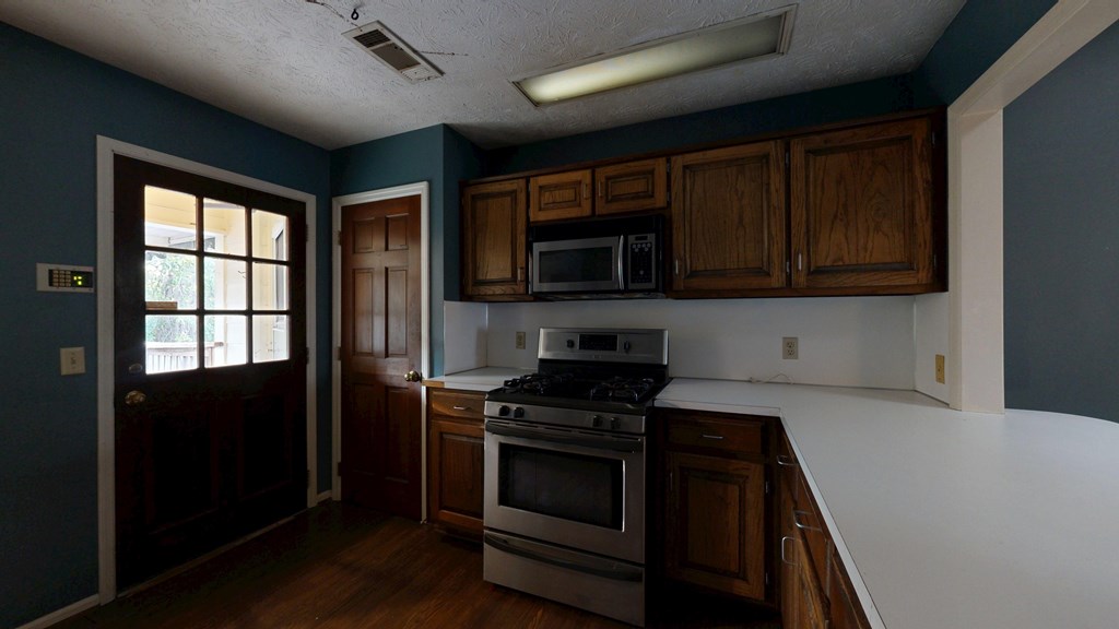 1237 Peacock Avenue Columbus, GA 31906 - Photo 32 of 52 a kitchen with granite countertop wooden cabinets stainless steel appliances and a window
