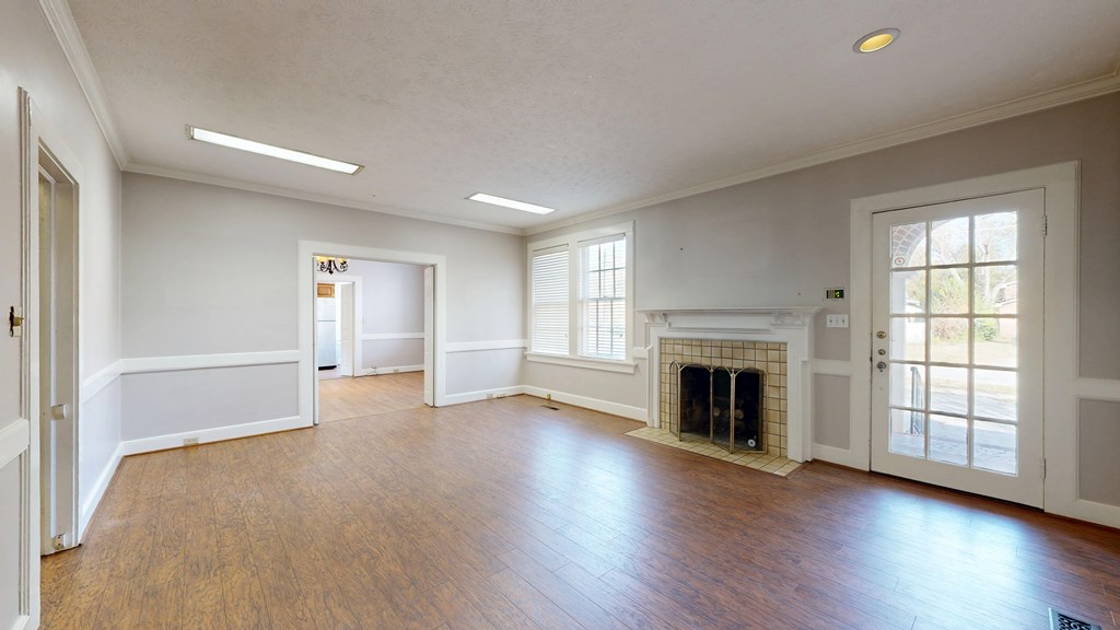 1237 Peacock Avenue Columbus, GA 31906 - Photo 5 of 52 an empty room with wooden floor fireplace and windows