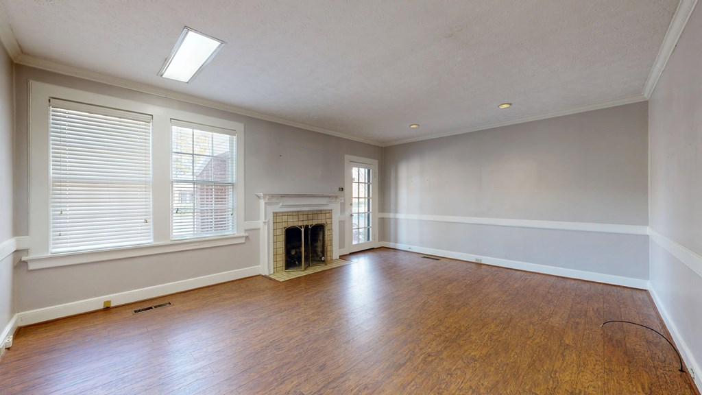 1237 Peacock Avenue Columbus, GA 31906 - Photo 6 of 52 an empty room with wooden floor fireplace and windows