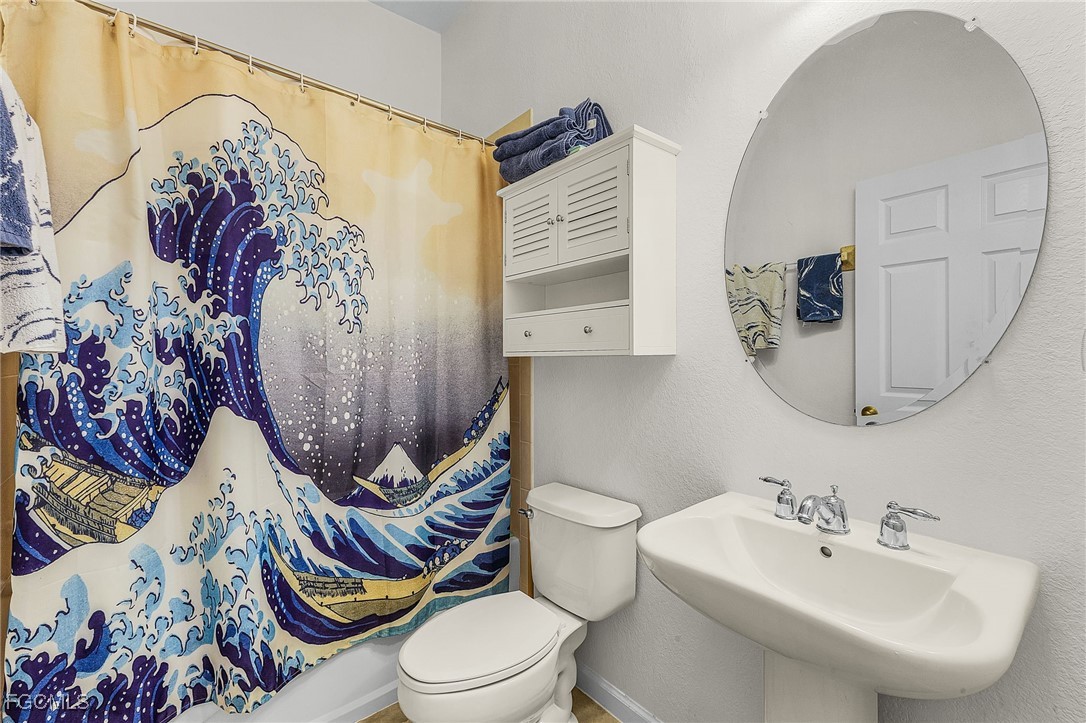 3900 Lakeview Isle Court Fort Myers, FL 33905 - Photo 20 of 31 a bathroom with a toilet sink and mirror