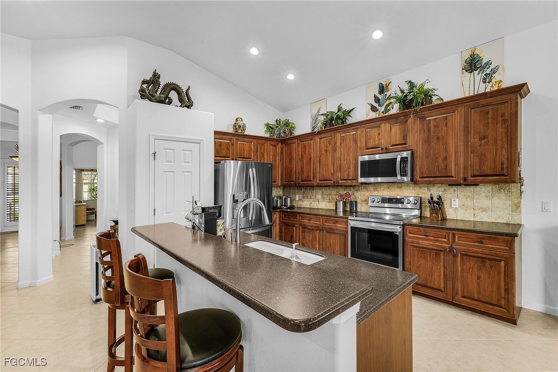 3900 Lakeview Isle Court Fort Myers, FL 33905 - Photo 7 of 31 a kitchen with stainless steel appliances a stove sink microwave and cabinets