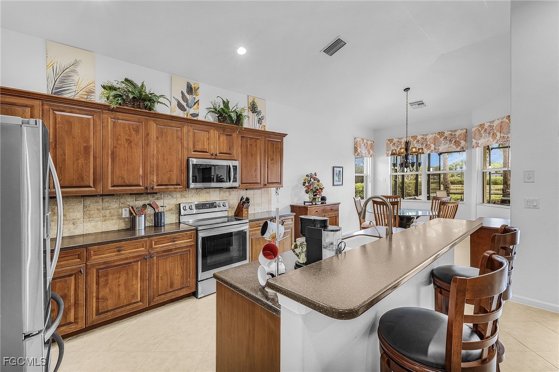 3900 Lakeview Isle Court Fort Myers, FL 33905 - Photo 8 of 31 a kitchen with stainless steel appliances granite countertop a sink a stove and a refrigerator
